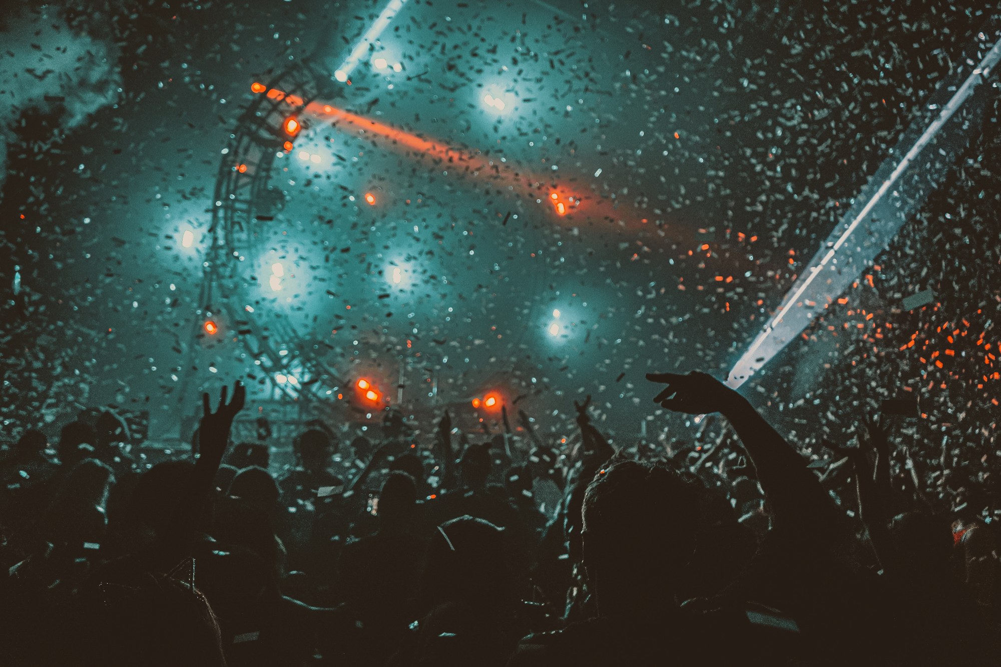 Dansende bezoekers tijdens een feest met rood licht en confetti